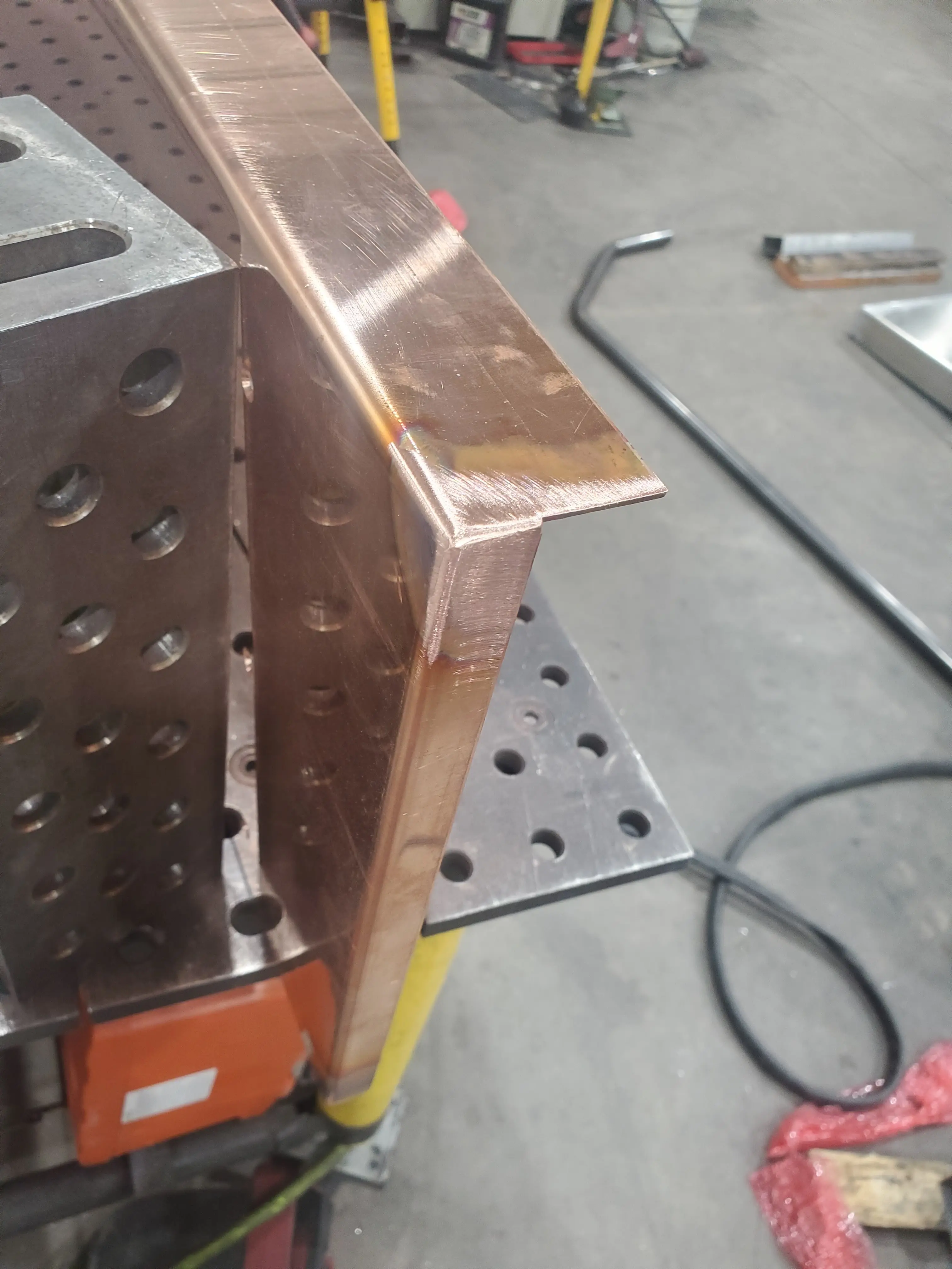 A hand-formed copper corner detail on the fabrication bench