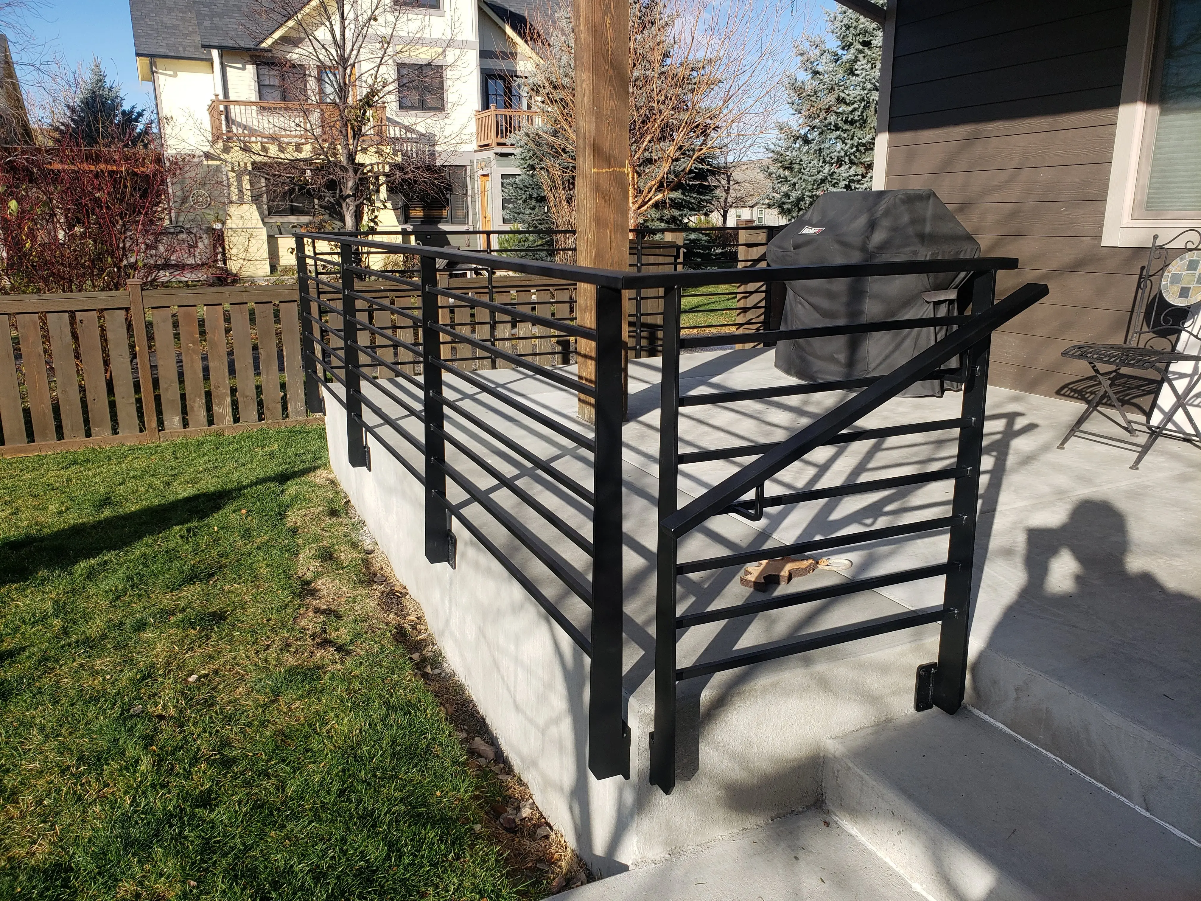 An exterior deck with a black horizontal-bar steel railing