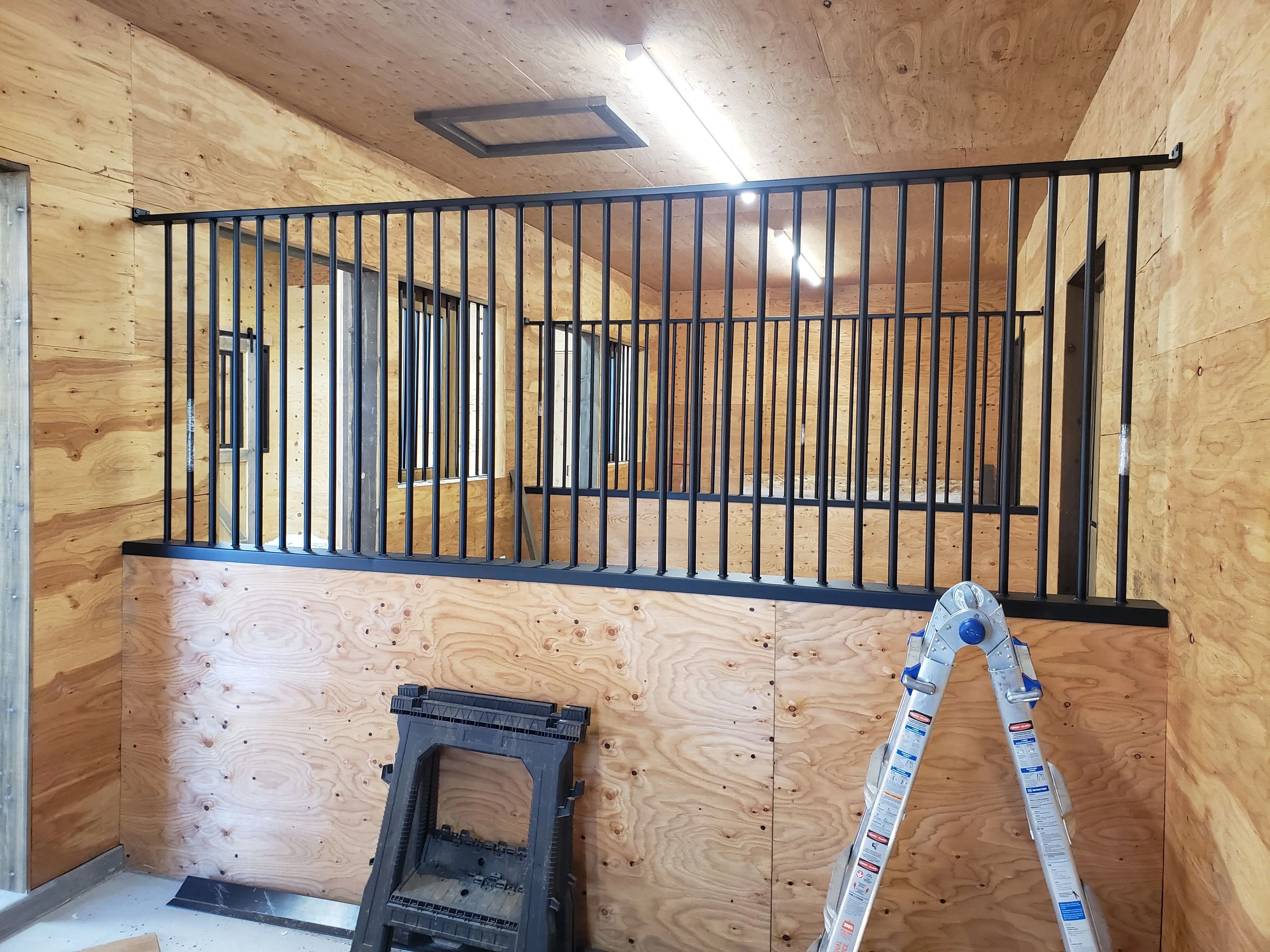 A loft railing with vertical steel bars in a timber-lined cabin