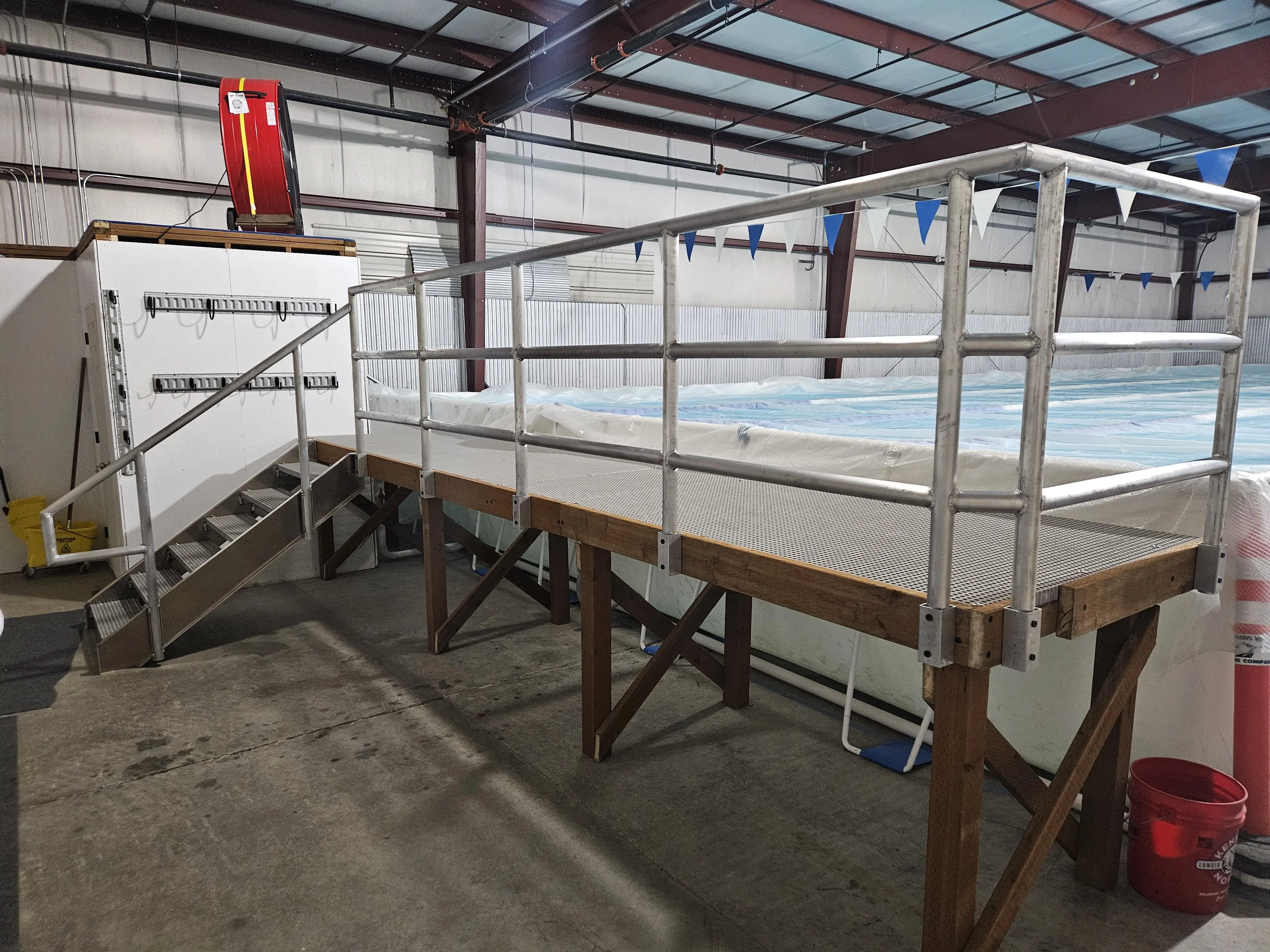 An aluminum pool-access platform and stair with mesh decking