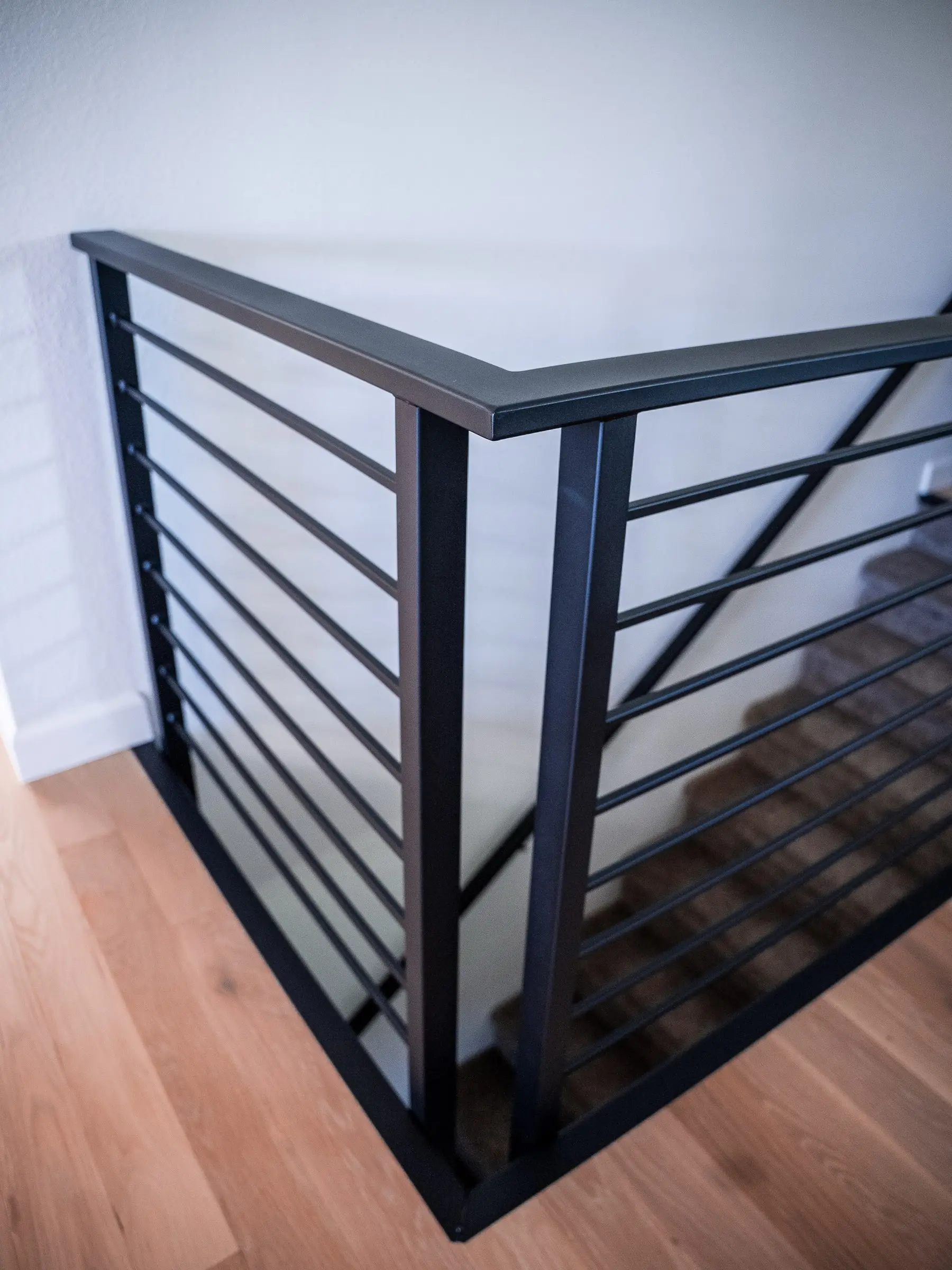 Black steel railing with a horizontal-bar design at an interior corner