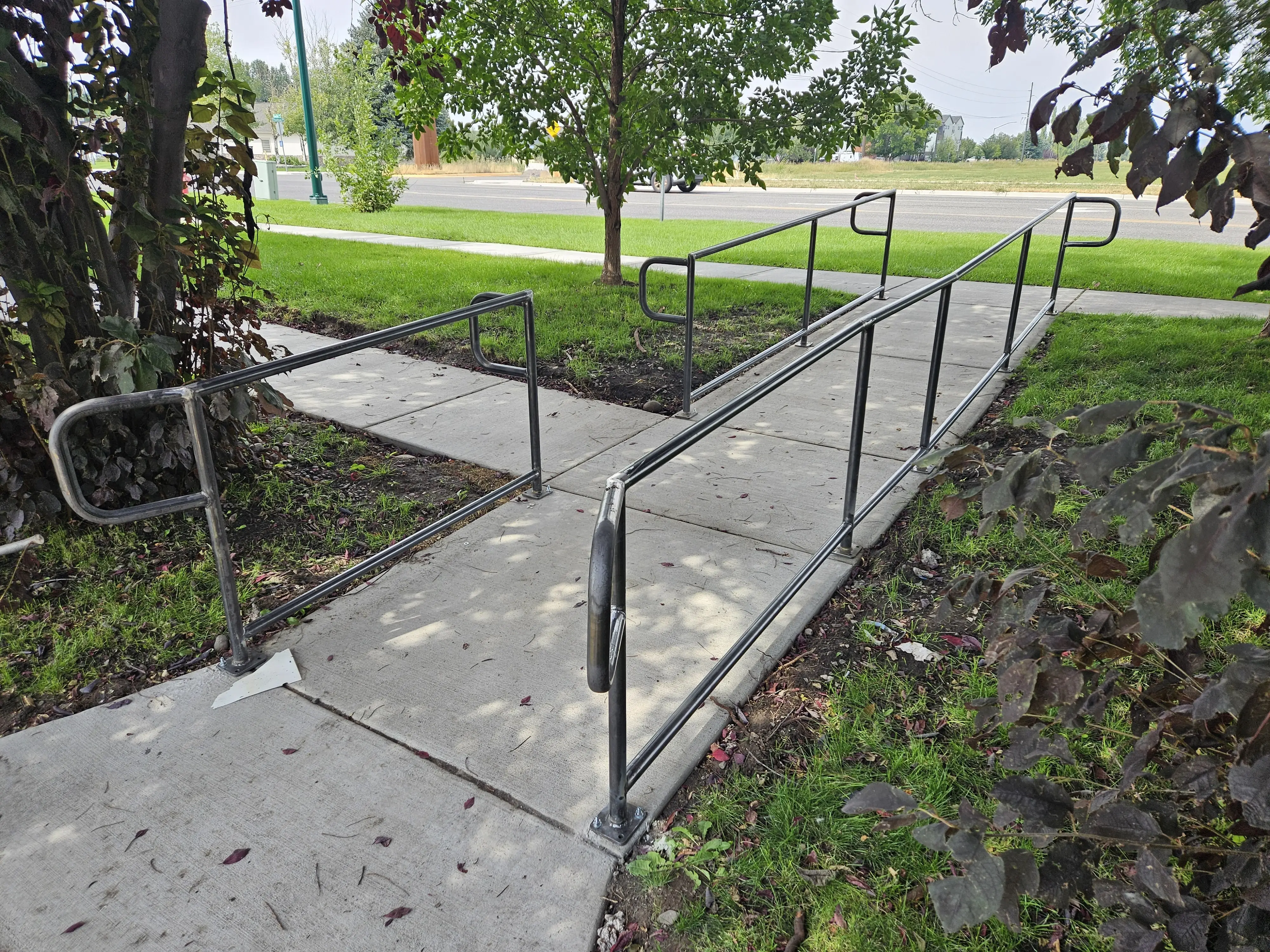 A galvanized steel accessibility ramp with tube handrails